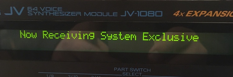Roland JV-1080 synthesizer receiving a MIDI System Exclusive message.